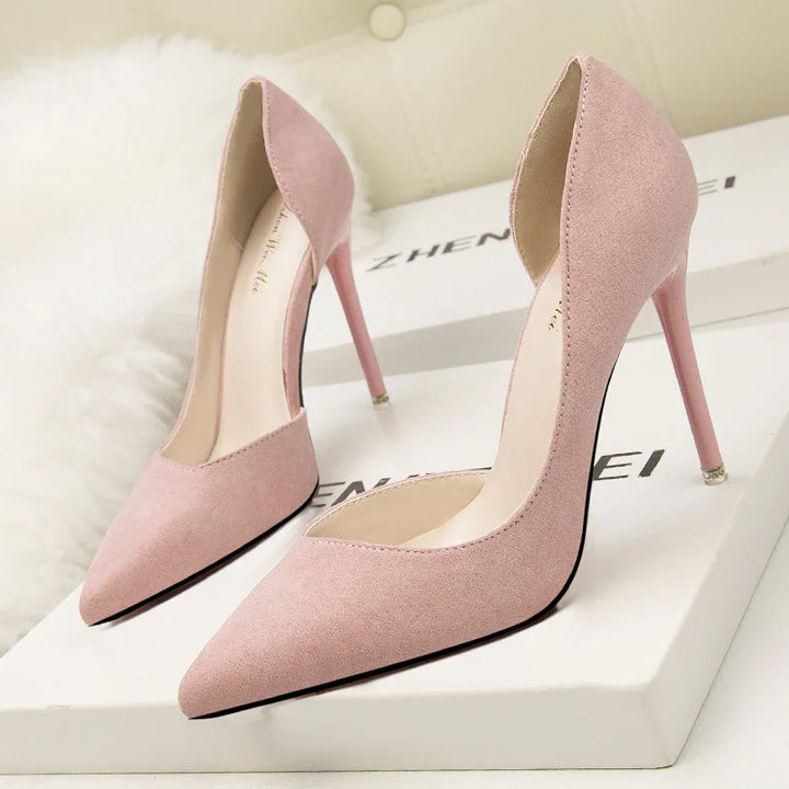 Pair of elegant pink suede high heels with pointed toes on white branded boxes