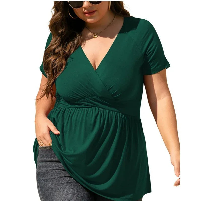 Plus size woman wearing a dark green short sleeve wrap top with v-neck and black jeans