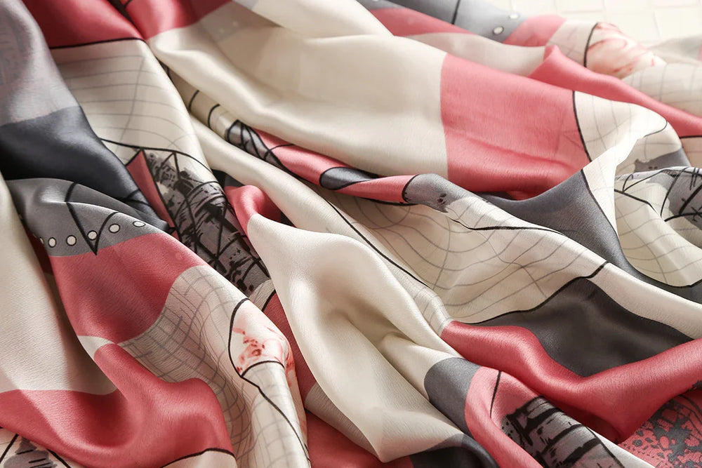 Close-up of soft silk fabric with abstract pink, black, and white geometric print