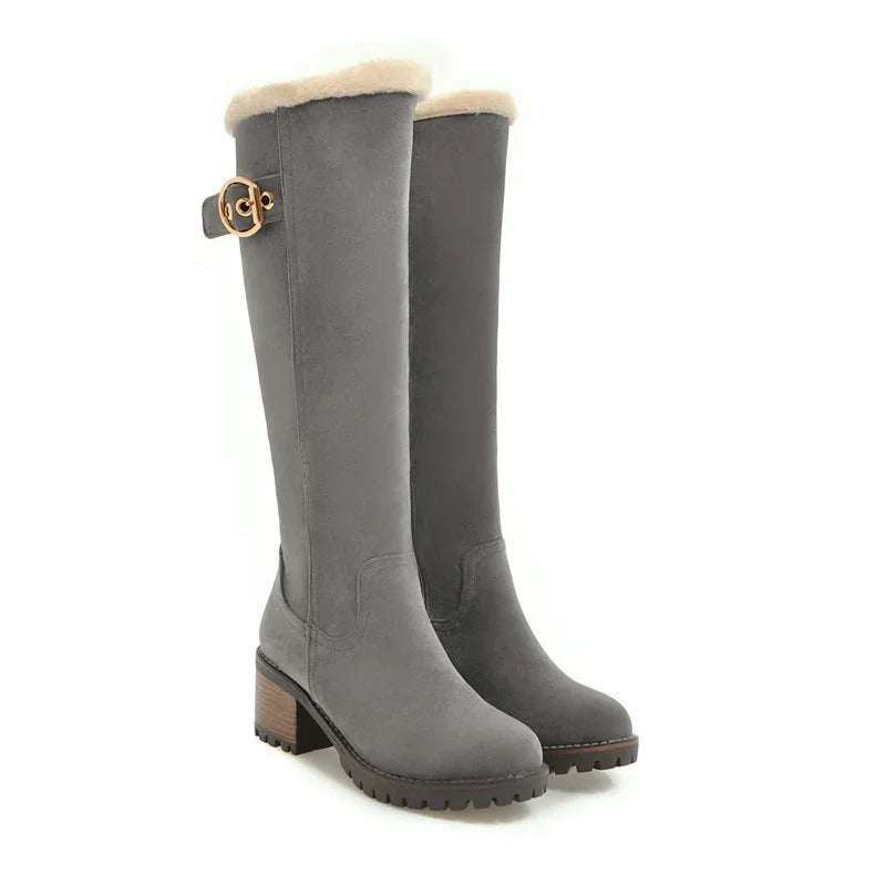 Pair of tall gray suede winter boots with fur lining and chunky wooden heels