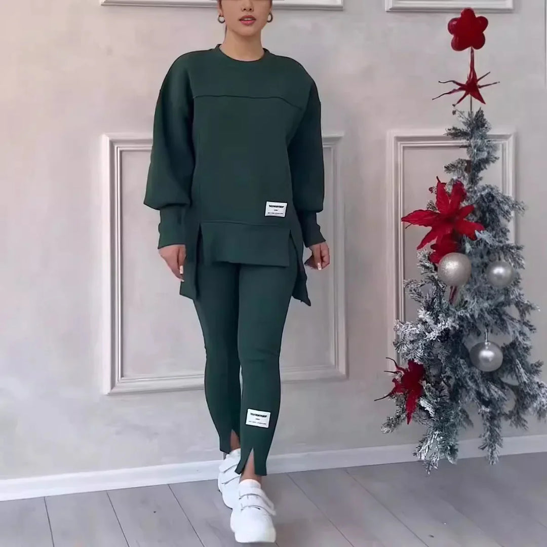 Woman modeling dark green casual two-piece outfit with white sneakers near decorated Christmas tree