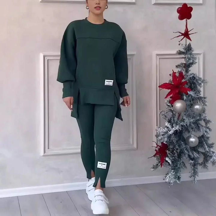 Woman modeling dark green casual two-piece outfit with white sneakers near decorated Christmas tree