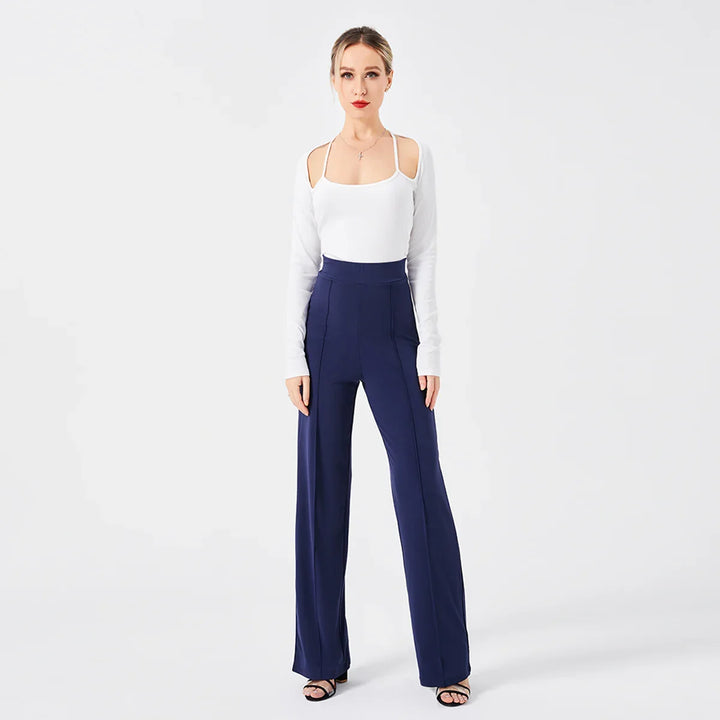 Woman wearing white cold shoulder top and high waist navy blue wide-leg pants on white background