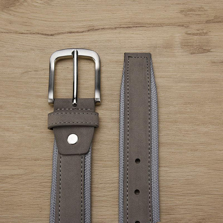 gray fabric and leather belt with silver buckle on wooden surface