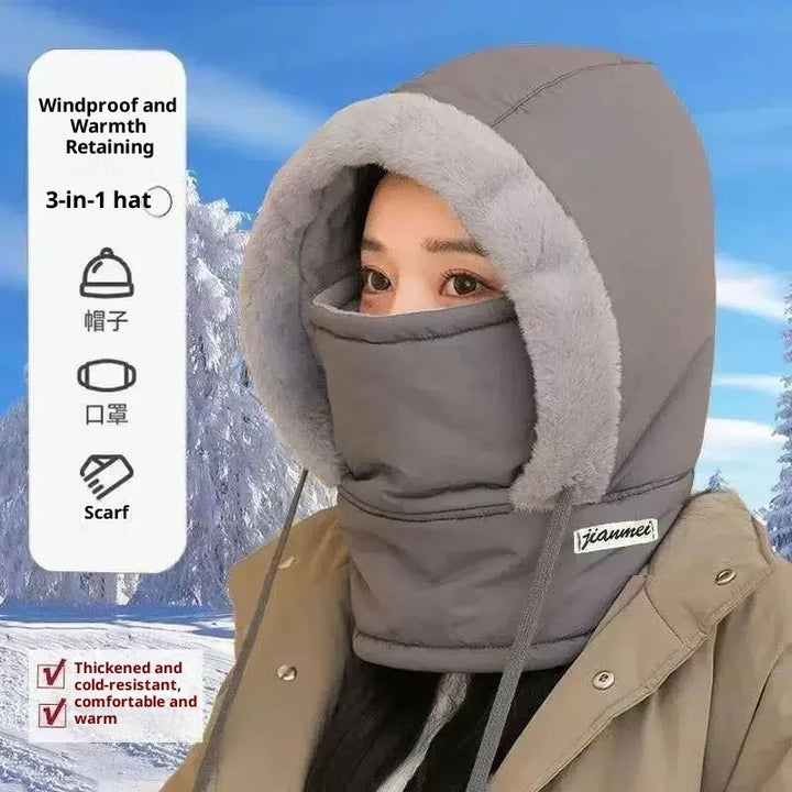 Woman wearing thick gray 3-in-1 windproof hat, mask, and scarf with fur trim in snowy outdoor setting
