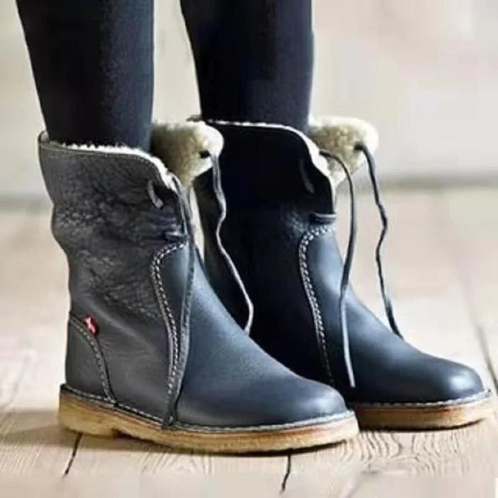 black leather winter boots with shearling lining and wooden soles worn with black leggings