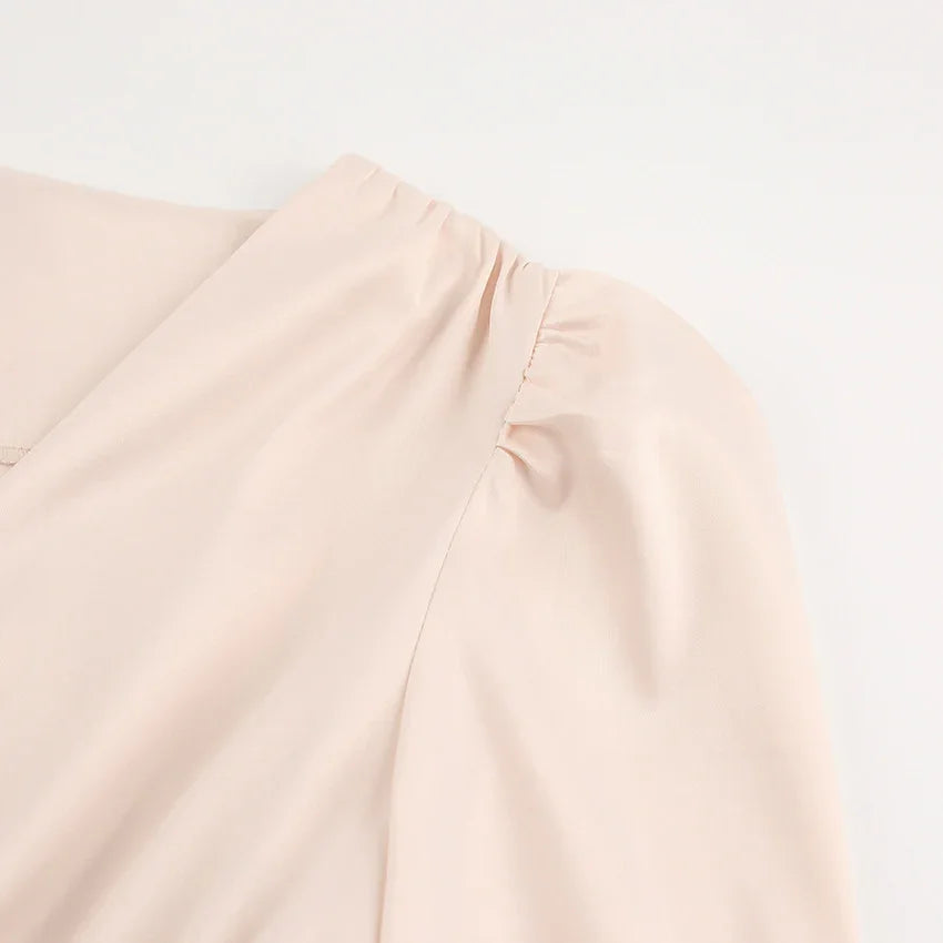 Close-up of beige puff sleeve on smooth lightweight fabric blouse