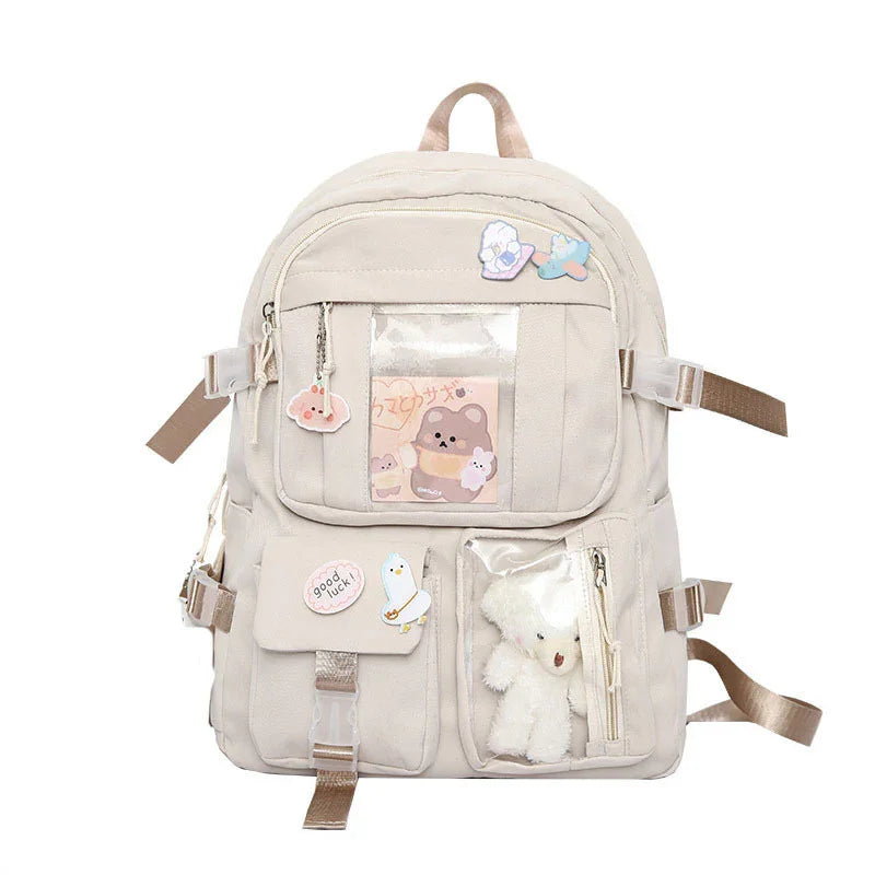 Beige canvas backpack with teddy bear, stickers, and clear front pockets for cute accessories