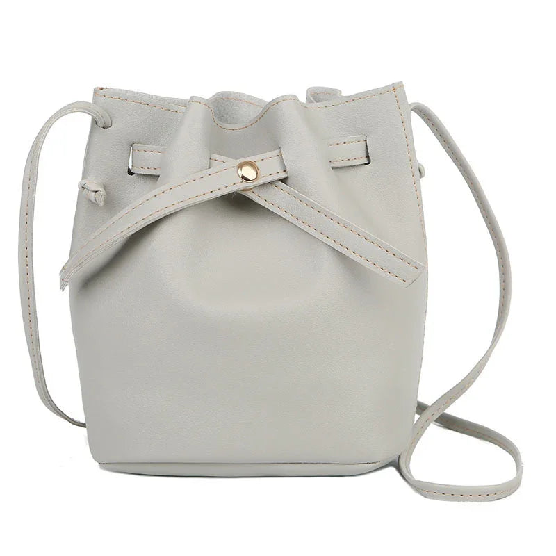 Light gray leather bucket bag with adjustable strap and gold button detail
