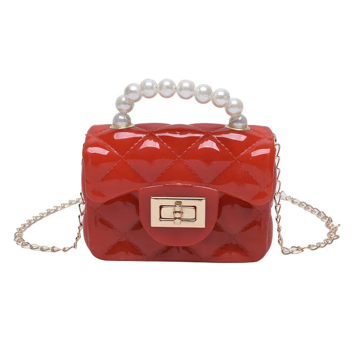 Red quilted mini handbag with pearl handle and gold chain strap on white background