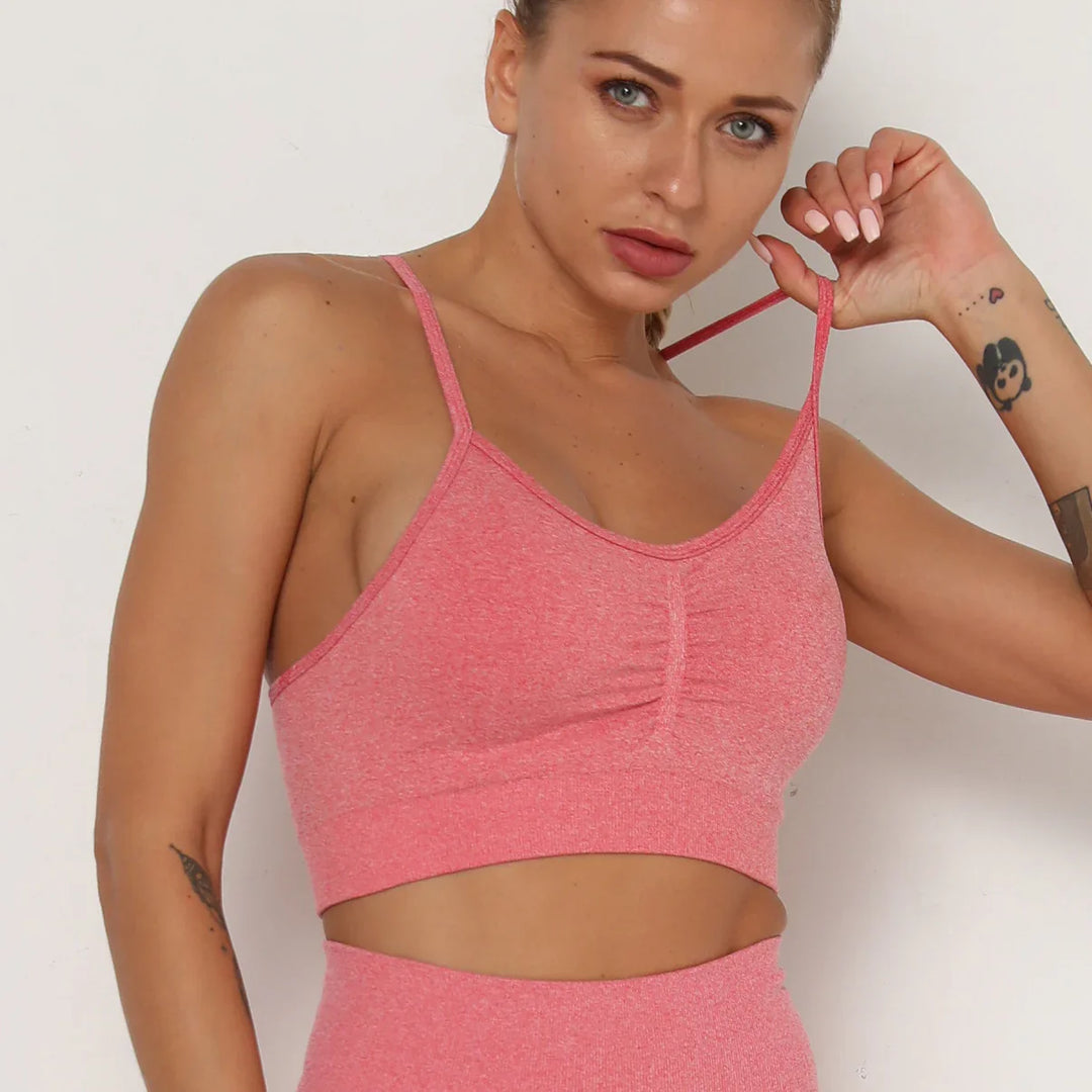 Close-up of woman wearing pink seamless workout crop top with thin straps and matching leggings
