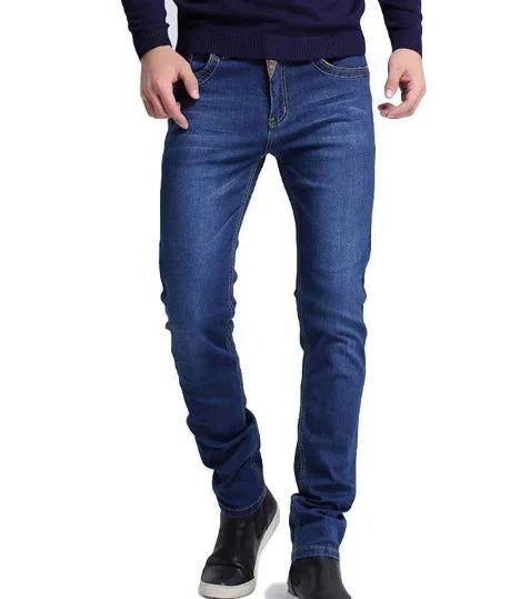 Man wearing dark blue slim fit jeans and black shoes with white soles on white background