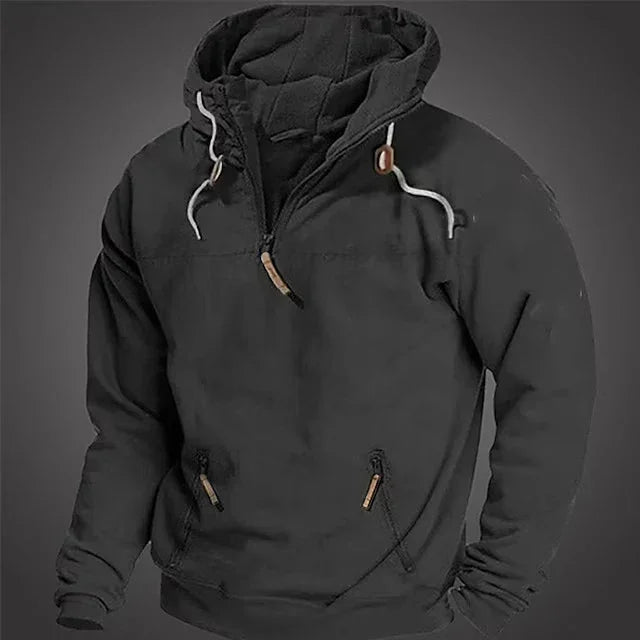 Black hooded sweatshirt with front zip, white drawstrings, and zippered pockets on gray background