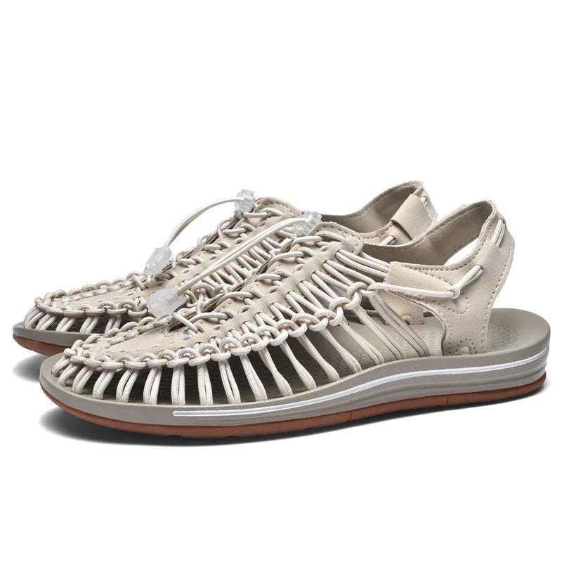 Beige woven sandals with elastic cord lacing and rubber sole on white background