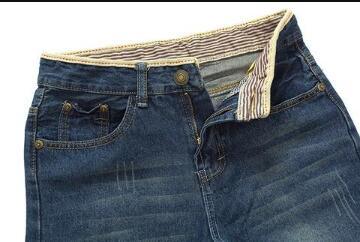 Dark blue denim jeans with striped inner waistband and partially unbuttoned fly