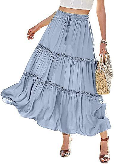 woman wearing light blue tiered maxi skirt with drawstring waist and white crop top, holding woven bag