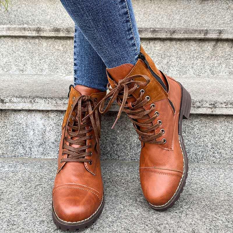 Brown leather lace-up ankle boots with zipper detail worn with blue jeans on stone steps
