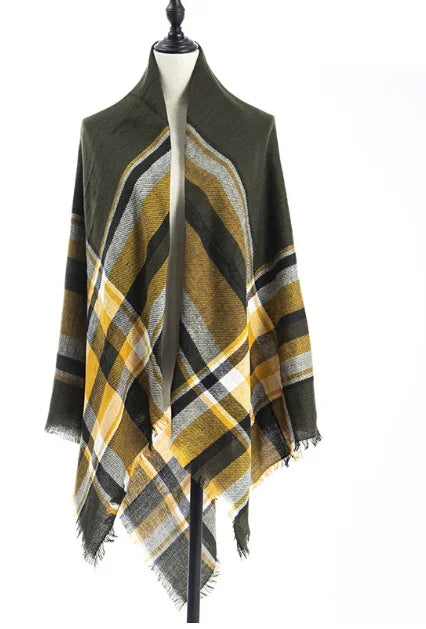 Olive green and mustard yellow plaid fringed shawl draped on dress form against white background