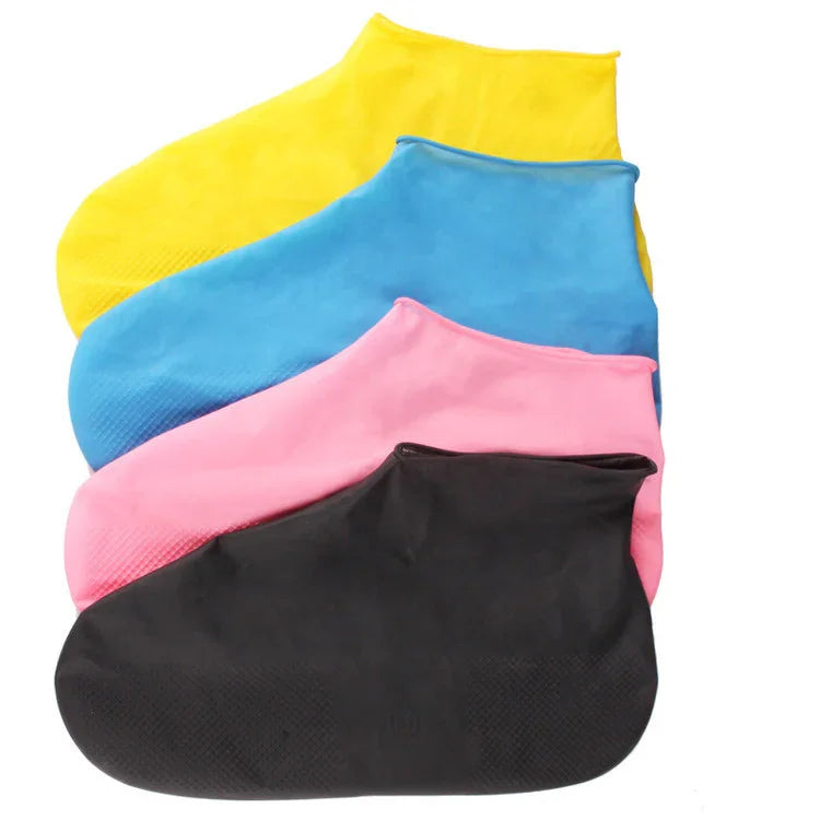 Set of four colorful waterproof shoe covers in yellow, blue, pink, and black on white background