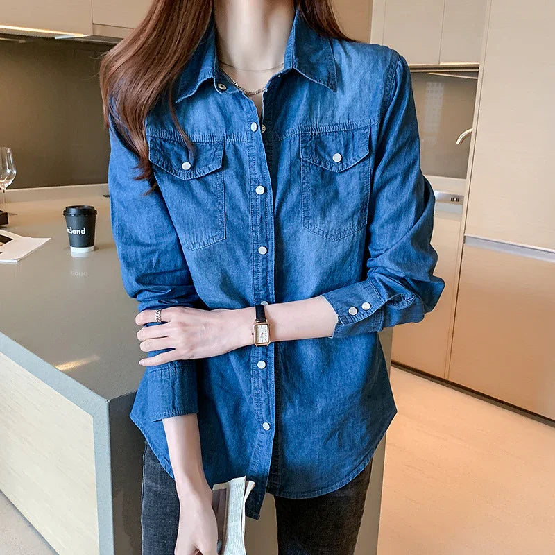 Woman wearing a blue denim shirt with buttoned pockets standing in a modern kitchen