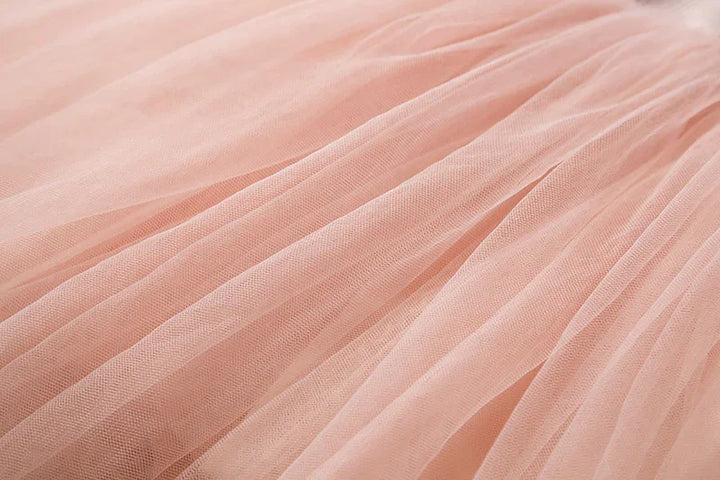 Close-up of soft pink tulle fabric with fine mesh texture and delicate folds