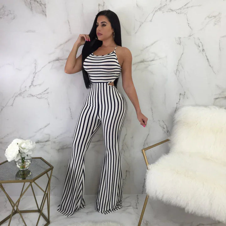 Woman wearing black and white vertical striped jumpsuit with side cutouts posing against marble wall