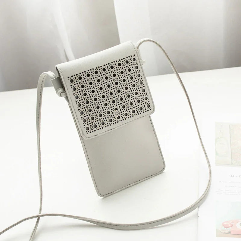 Minimalist light gray crossbody phone bag with perforated geometric flap design on white surface