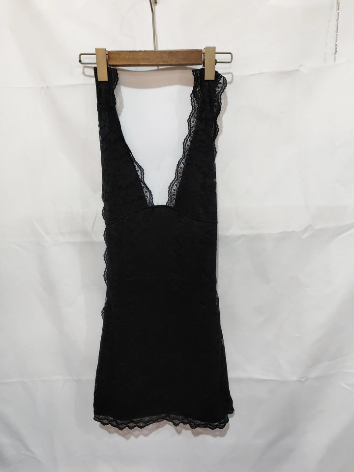 Black lace sleeveless dress with deep V-neck hanging on wooden hanger against white background