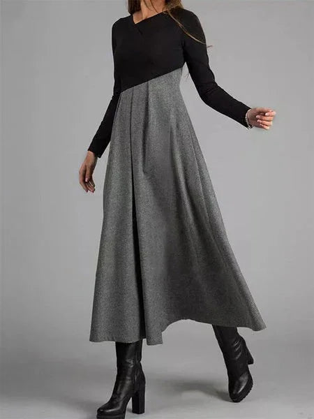 woman wearing long black and gray color block dress with long sleeves and black heeled boots