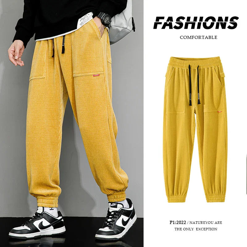 Yellow ribbed casual pants with drawstring waist and pockets, styled with black and white sneakers