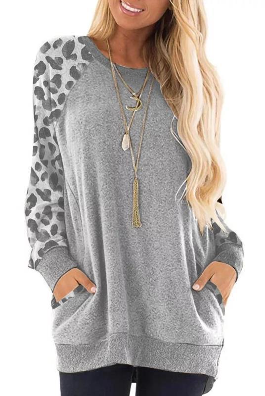Woman wearing grey long-sleeve casual top with leopard print sleeves and front pockets