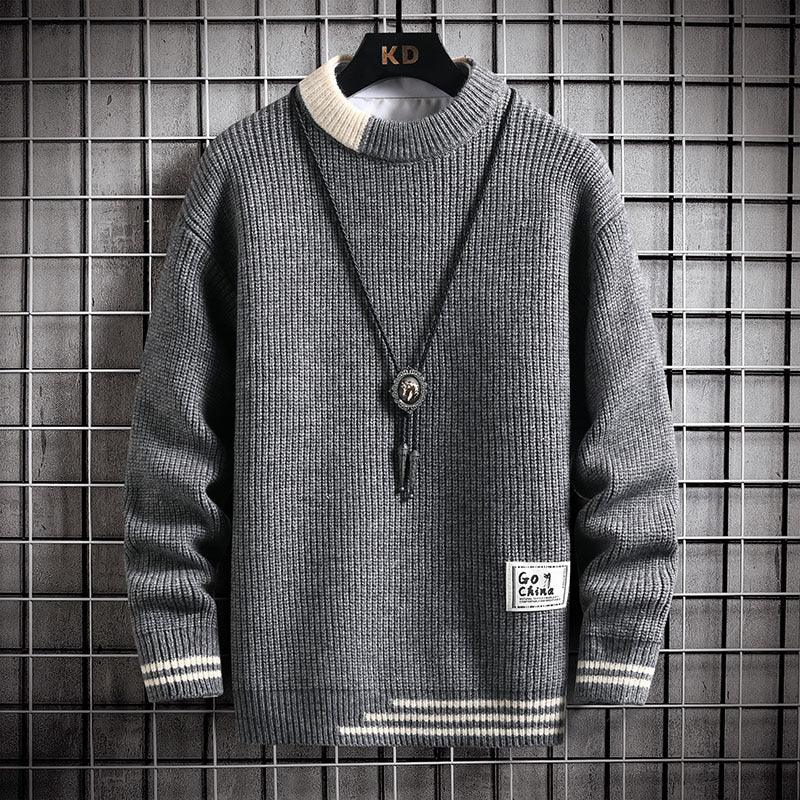 Gray knitted sweater with white collar and cuffs, striped hem, and a pendant necklace on a black hanger