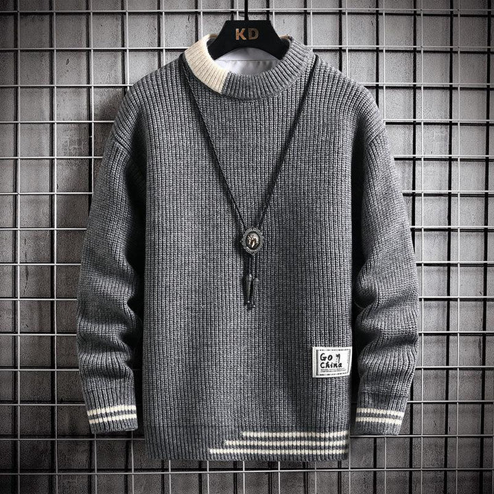 Gray knitted sweater with white collar and cuffs, striped hem, and a pendant necklace on a black hanger