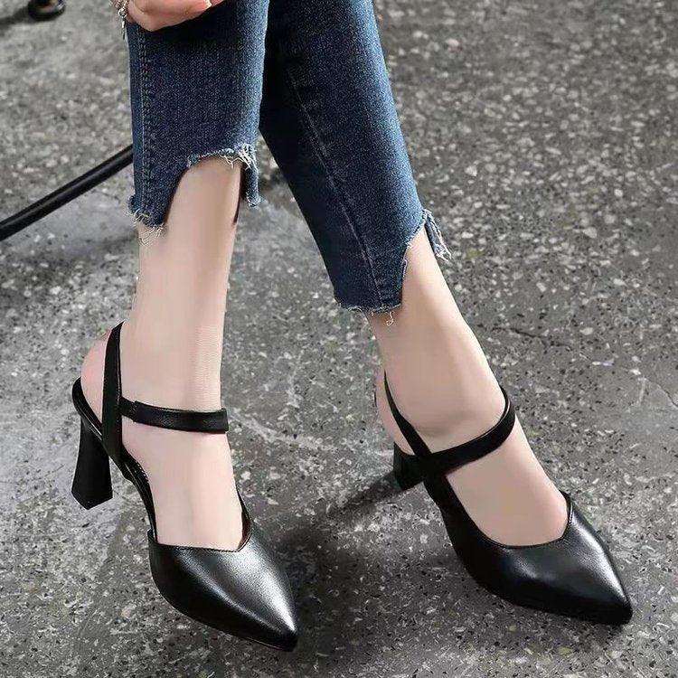 Woman wearing black pointed toe slingback high heel shoes with ankle straps and frayed hem jeans