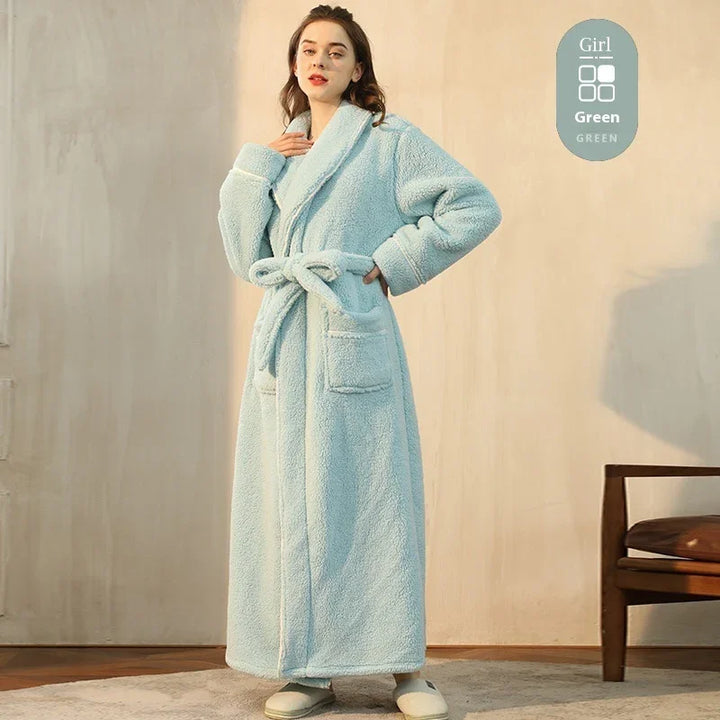 Woman wearing a long light blue fluffy bathrobe with pockets and belt indoors