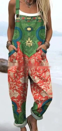 Woman wearing colorful floral patterned overalls with green, red, and beige design standing on a beach