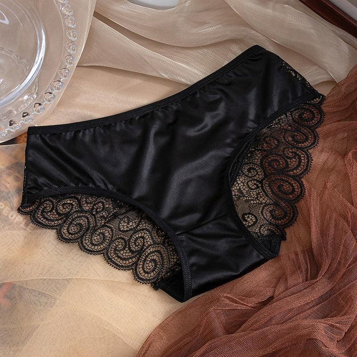 Black silky women's underwear with intricate lace trim on sheer fabric background