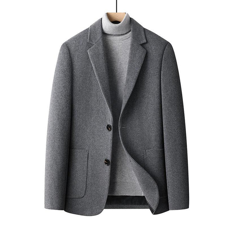 Gray wool blazer jacket layered over light gray turtleneck sweater on wooden hanger