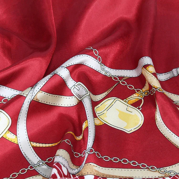Red silk fabric with white and gold chain and belt print design