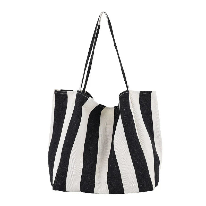 Black and white striped canvas tote bag with long handles on white background