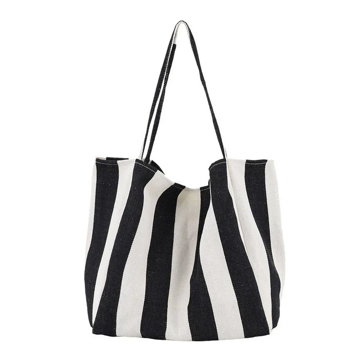 Black and white striped canvas tote bag with long handles on white background