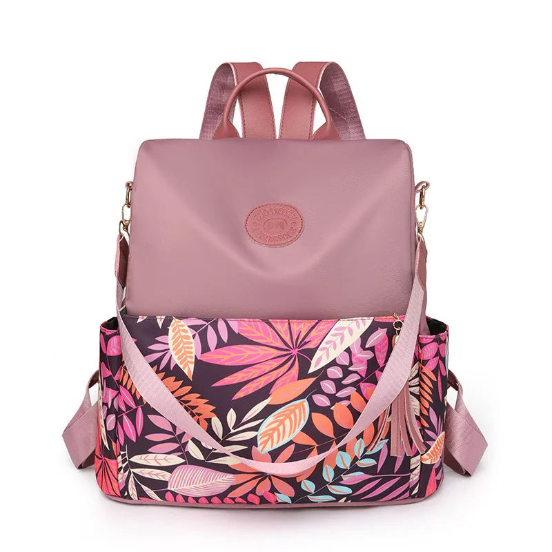 Pink leather backpack with colorful tropical leaf print and adjustable straps