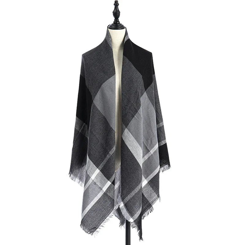Black and gray plaid shawl with fringed edges displayed on a mannequin