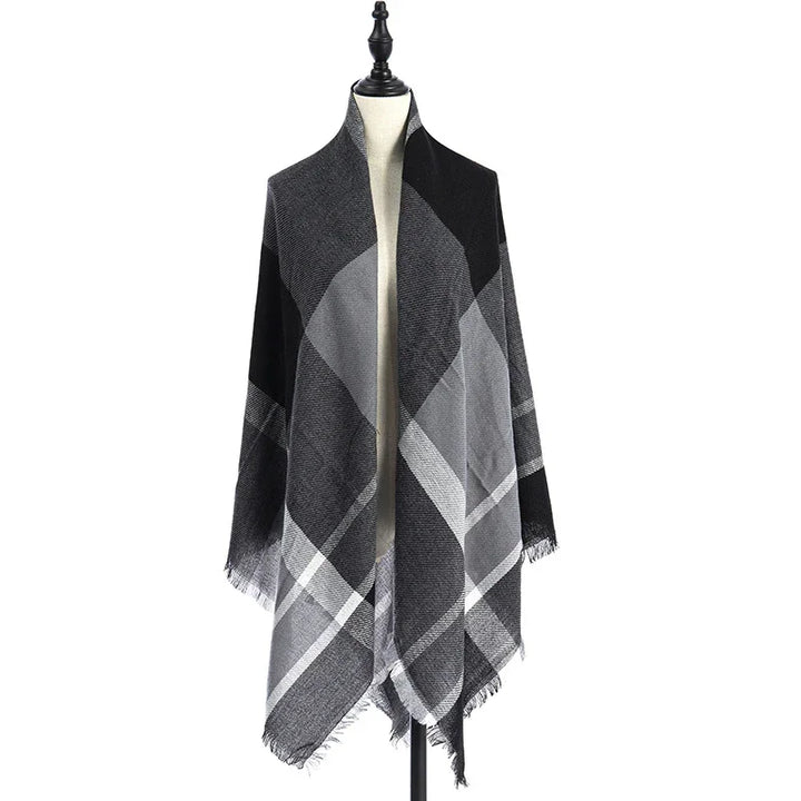 Black and gray plaid shawl with fringed edges displayed on a mannequin