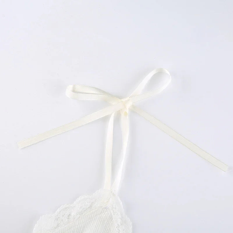 Cream white lace trim spaghetti strap with delicate ribbon bow detail on plain background