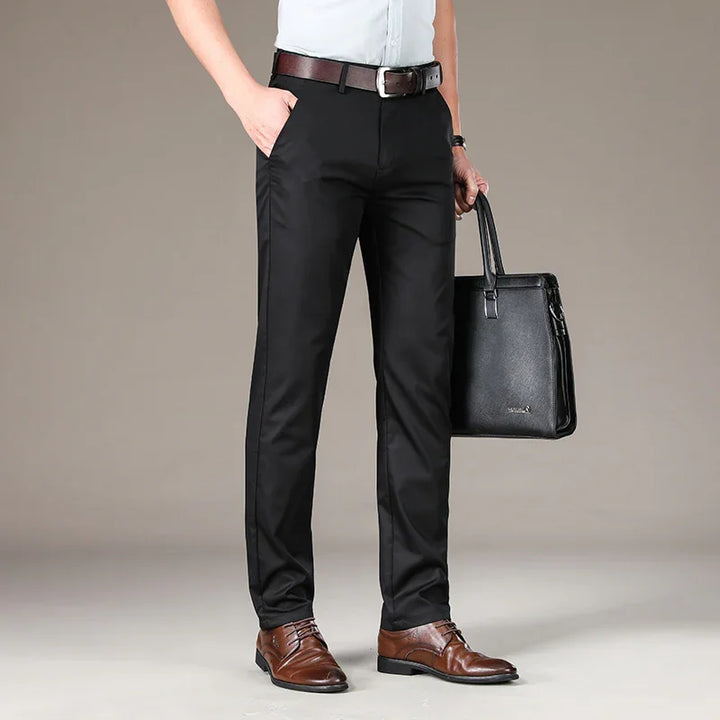man wearing black dress pants, brown leather belt, brown dress shoes, holding black leather briefcase