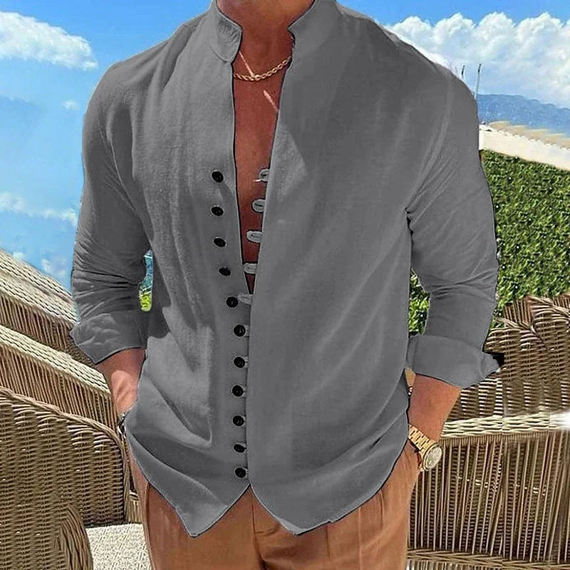 Man wearing a stylish grey mandarin collar shirt with rolled sleeves and brown pants outdoors