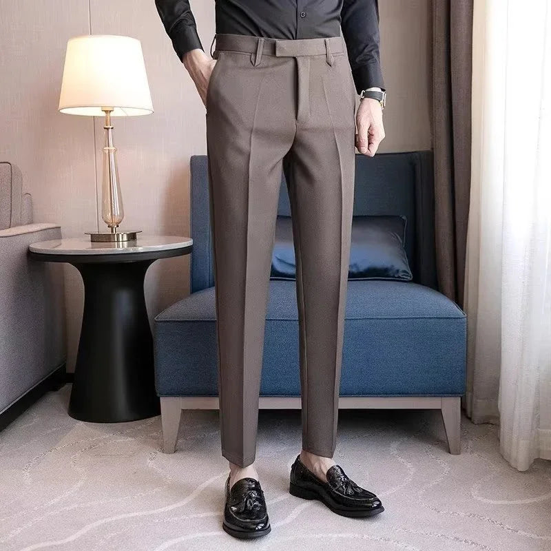Man wearing brown slim-fit dress pants and black tassel loafers standing indoors