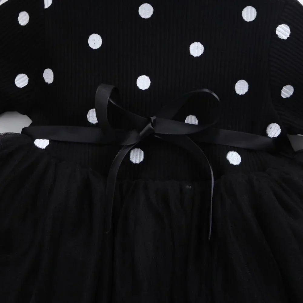 Black dress with white polka dots, tulle skirt, and a tied black satin ribbon belt