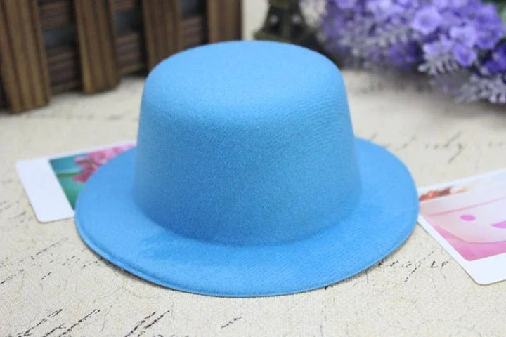 Light blue felt hat with a round crown and wide brim on textured fabric surface with purple flowers background